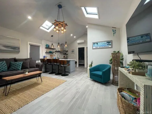 a living room with furniture kitchen view and a chandelier