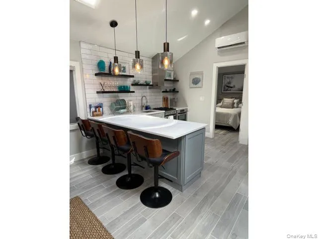 a kitchen with stainless steel appliances granite countertop a sink dishwasher and a refrigerator with wooden floor