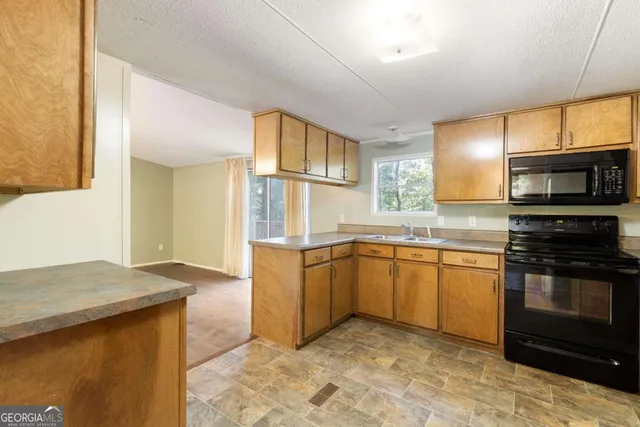 a kitchen with stainless steel appliances granite countertop a sink stove and microwave