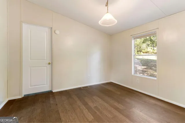 an empty room with a bathroom and mirror