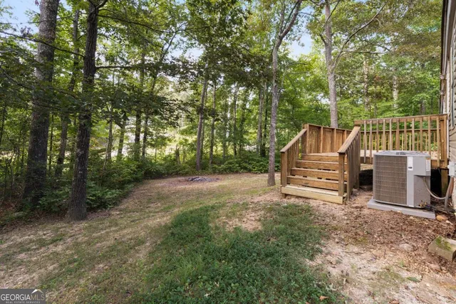 a view of backyard with deck and trees