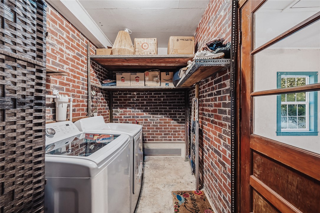 209 Cleveland Pike Road Westminster, SC 29693 - Photo 25 of 30 Exposed brick walls offer a rustic backdrop to a functional and well-equipped laundry space.