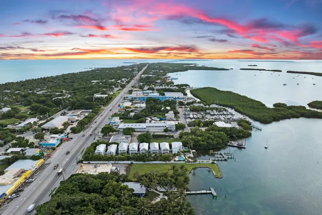 an aerial view of ocean and residential houses with outdoor space
