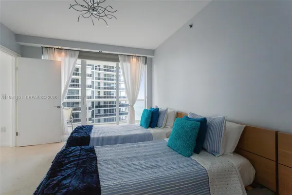 a bedroom with a large bed and a chandelier