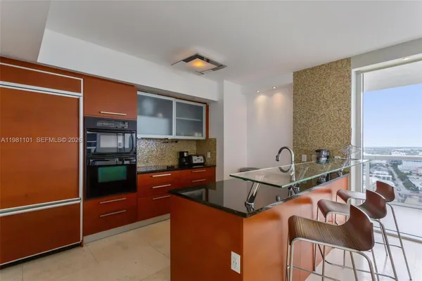 a kitchen with stainless steel appliances granite countertop a sink refrigerator and cabinets
