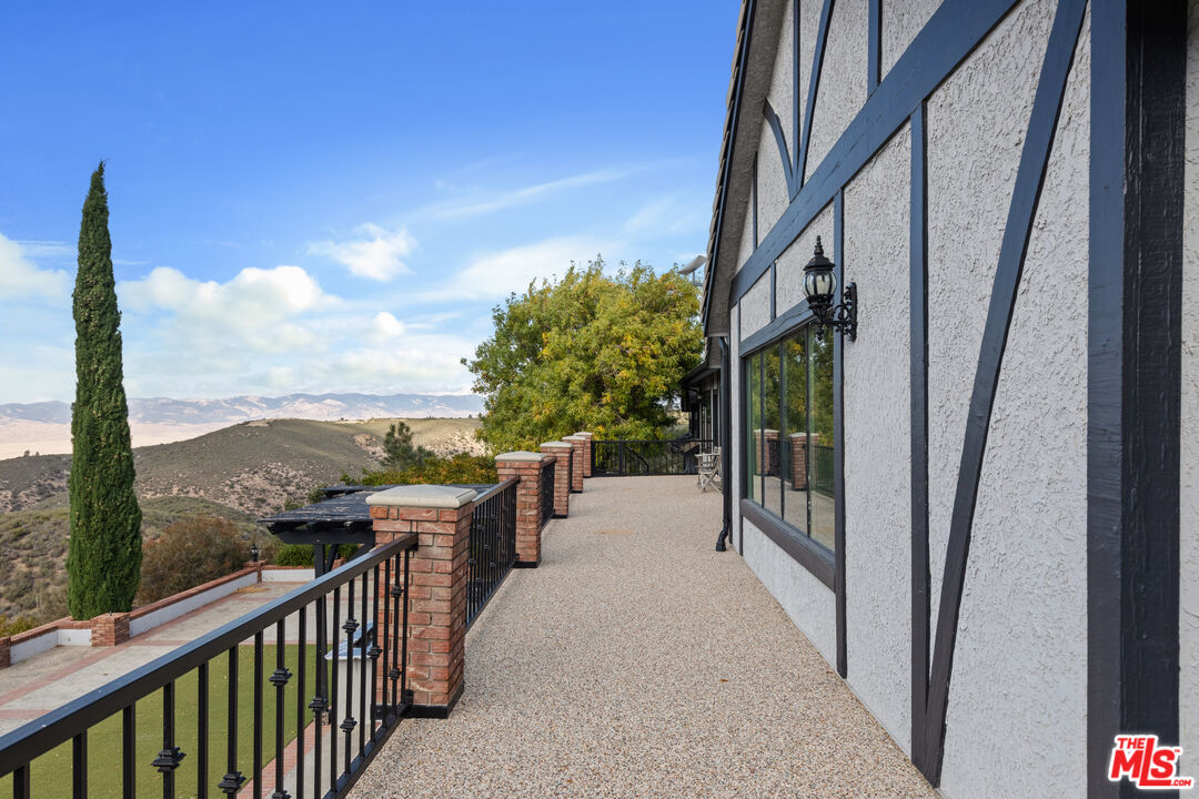 28765 Pine Canyon Road Lake Hughes, CA 93532 - Photo 47 of 58 a view of a balcony with couches and wooden floor