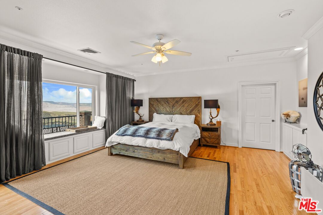 28765 Pine Canyon Road Lake Hughes, CA 93532 - Photo 49 of 58 a spacious bedroom with a bed and a chandelier