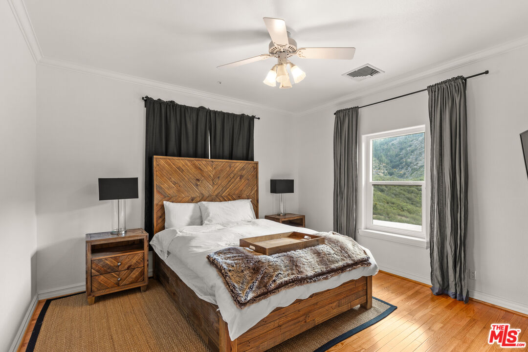 28765 Pine Canyon Road Lake Hughes, CA 93532 - Photo 52 of 58 a bedroom with a large bed and a chandelier