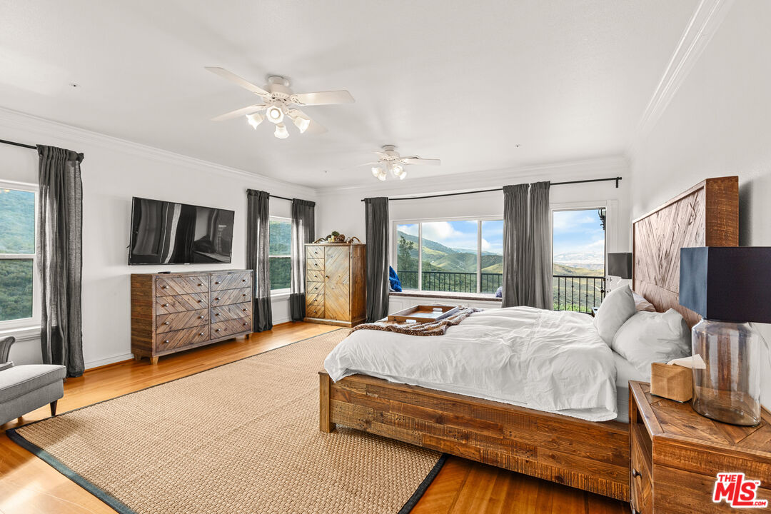 28765 Pine Canyon Road Lake Hughes, CA 93532 - Photo 53 of 58 a bedroom with a bed flat screen tv and a large window
