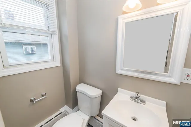 a bathroom with a sink a toilet and mirror