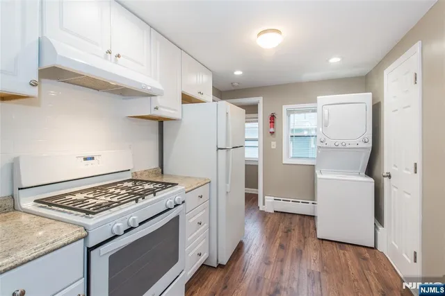 a kitchen with a stove a refrigerator and wooden floor