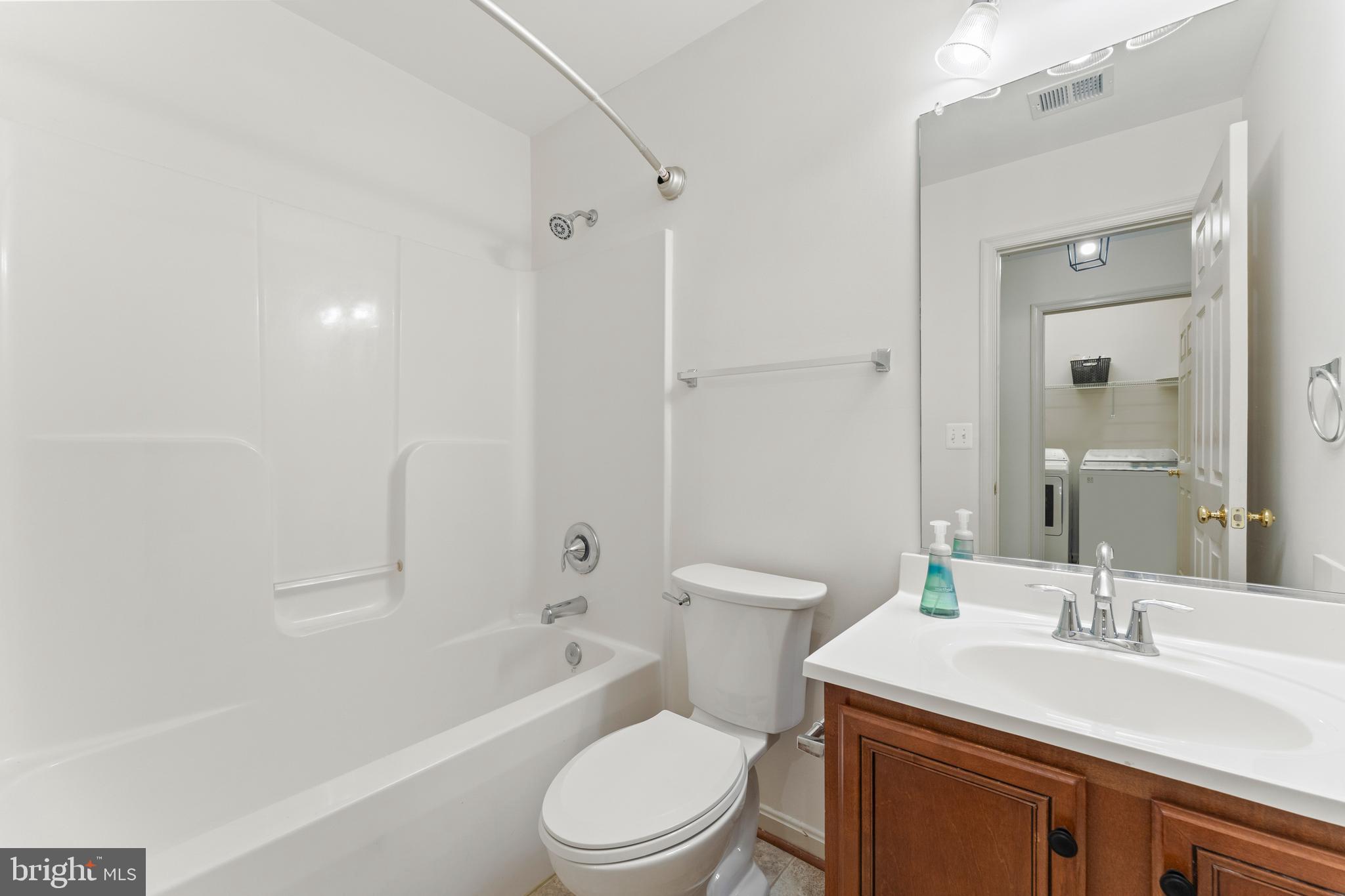 18350 Congressional Circle Ruther Glen, VA 22546 - Photo 33 of 55 a bathroom with a toilet a sink a mirror a bathtub and vanity