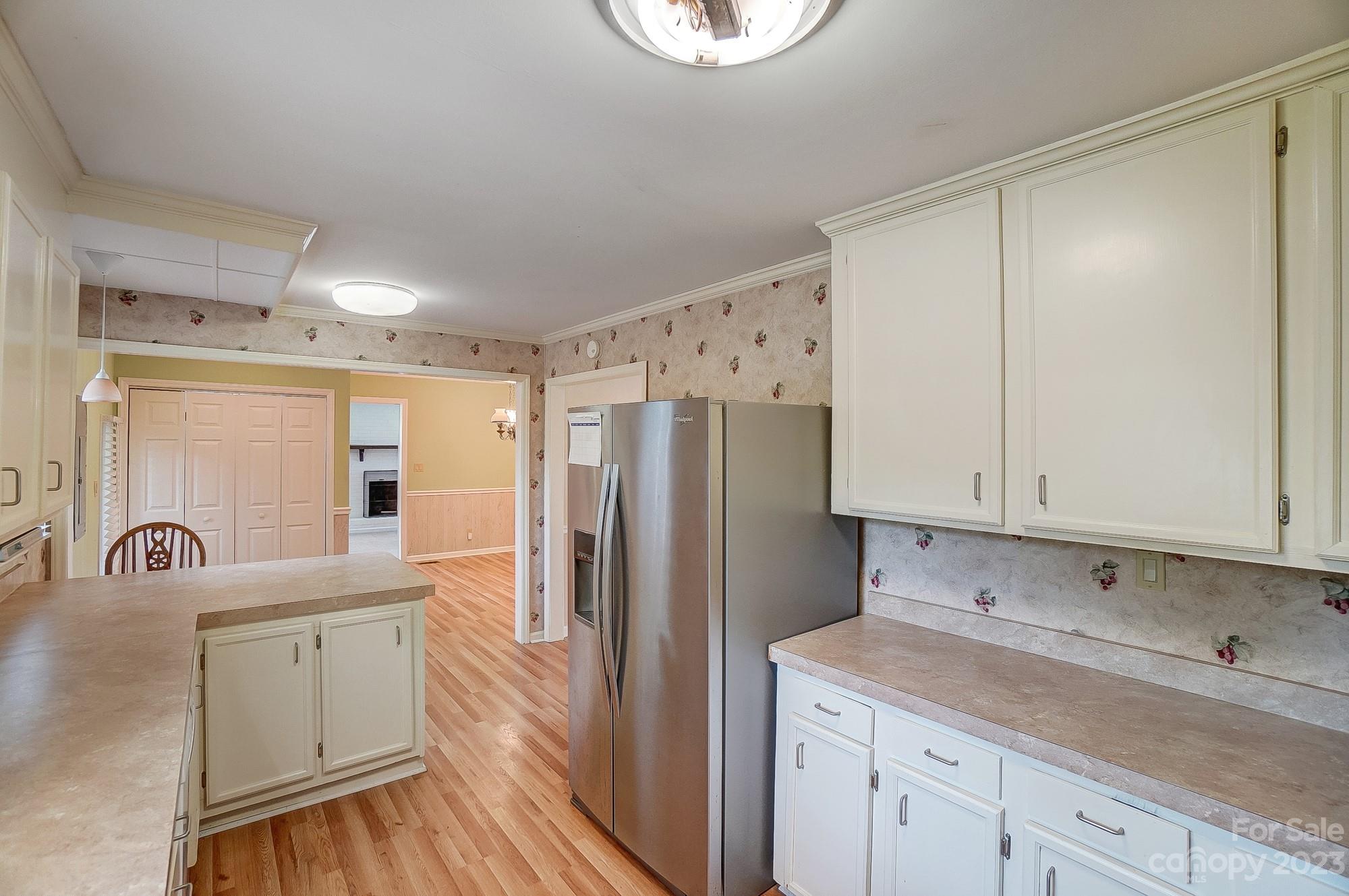 744 Ike Lynch Road Dallas, NC 28034 - Photo 13 of 47 a kitchen with a sink dishwasher a refrigerator and cabinets with wooden floor
