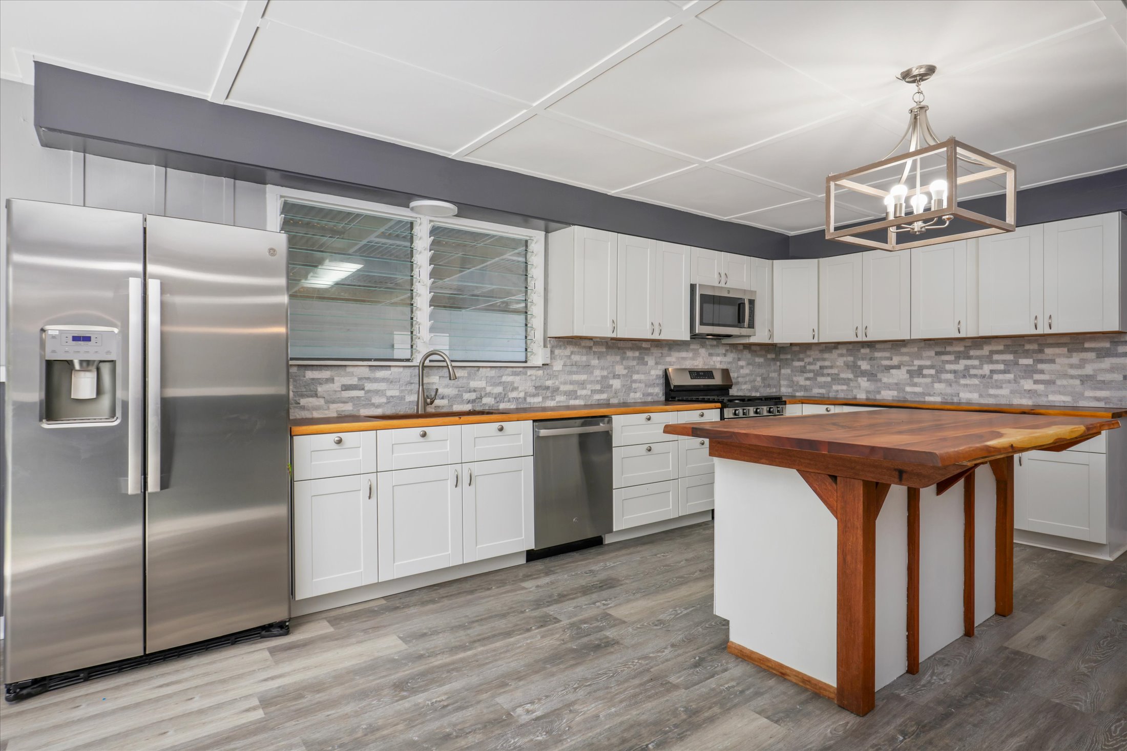 55-545 Hawi Road Hawi, HI 96719 - Photo 4 of 27 a kitchen with stainless steel appliances granite countertop a sink a stove a refrigerator and island with wooden floor