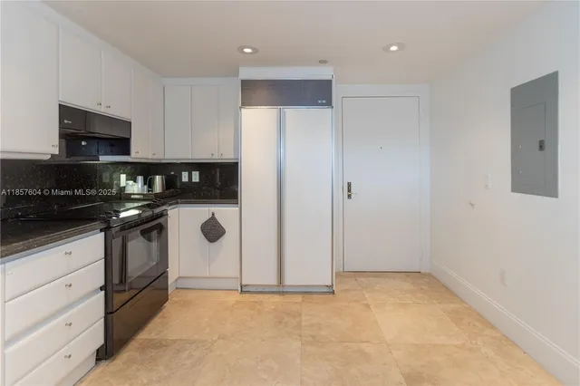 a kitchen with granite countertop white cabinets stainless steel appliances and sink