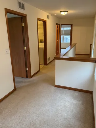 an empty room with mirror and a stairs