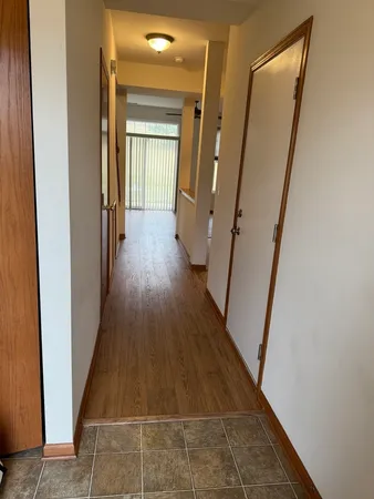 a view of a hallway with wooden floor and staircase