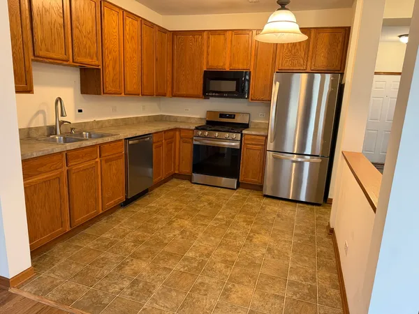 a kitchen with granite countertop a refrigerator and a sink