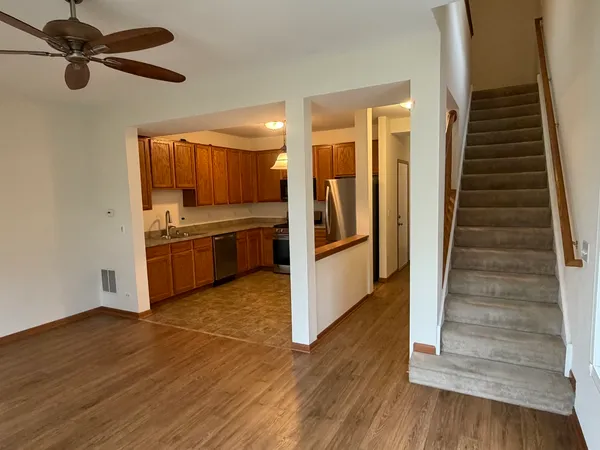 a view of kitchen with wooden floor electronic appliances and stairs