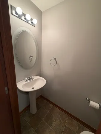 a bathroom with a sink mirror and toilet