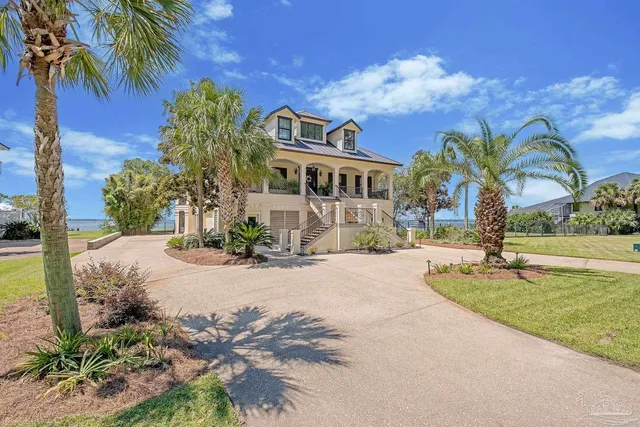 a view of a house with a yard and coconut trees