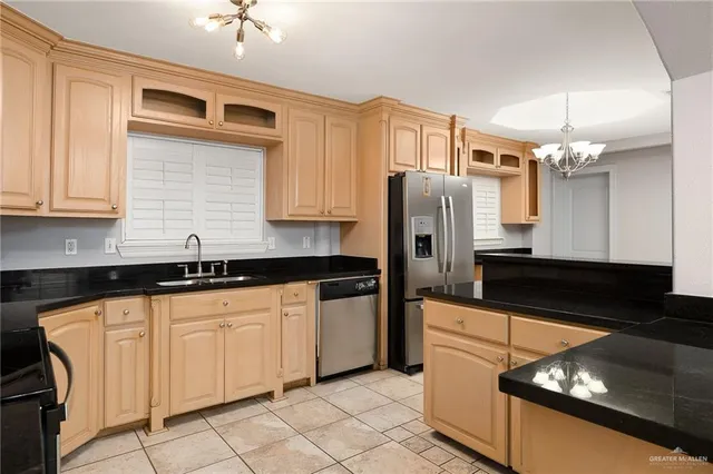 a kitchen with granite countertop a sink a stove and refrigerator