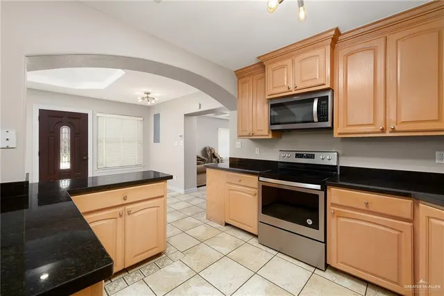 a kitchen with granite countertop white cabinets stainless steel appliances and a sink