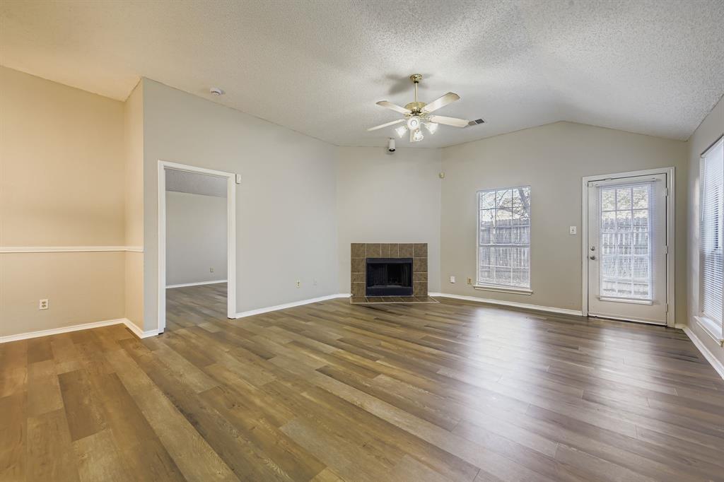1118 Colbert Lane Duncanville, TX 75137 - Photo 3 of 17 an empty room with wooden floor fan and windows