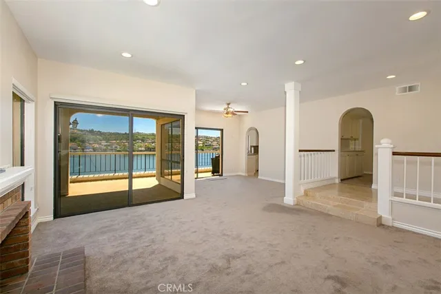 a view of an empty room with a fireplace and a large window