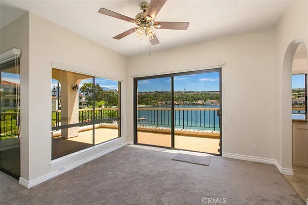 an empty room with sliding glass door and a chandelier fan