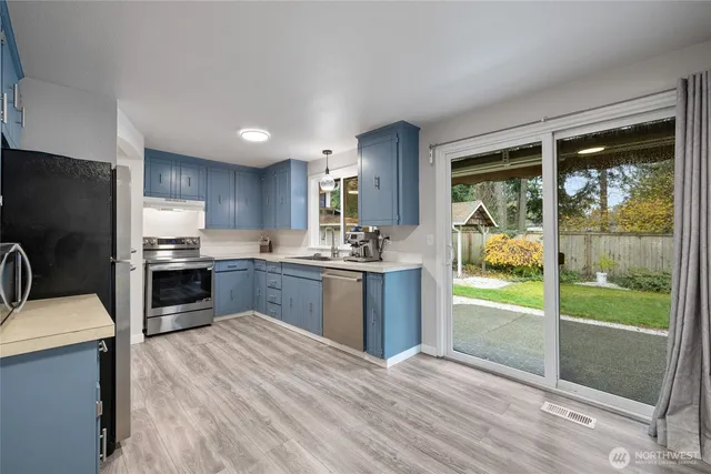 a kitchen with a refrigerator a stove top oven and a large window