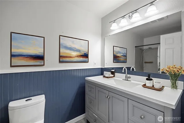 a bathroom with a toilet sink and mirror