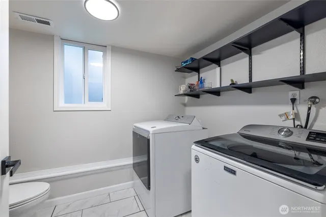 a utility room with sink dryer and washer