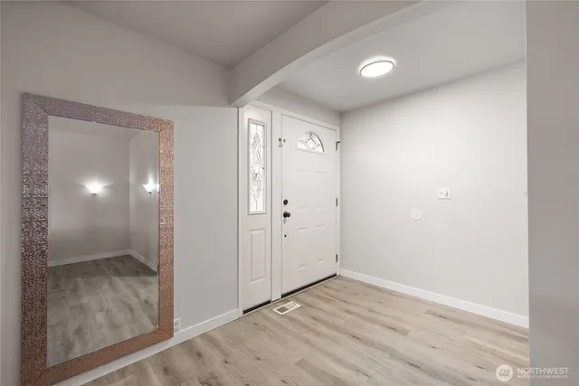 a view of an empty room with wooden floor