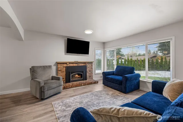 a living room with furniture a fireplace and a flat screen tv