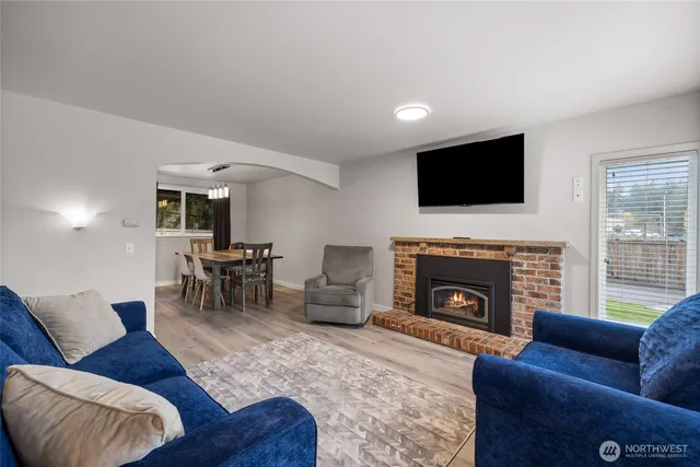 a living room with furniture a fireplace and a flat screen tv