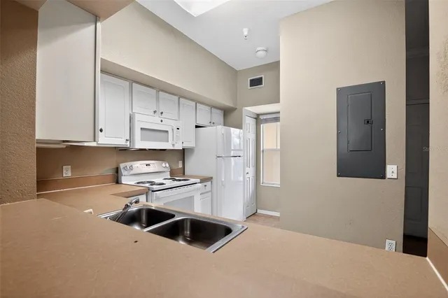 a kitchen with granite countertop white cabinets and white appliances