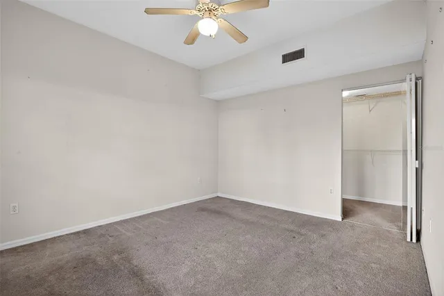 an empty room with a ceiling fan and a window