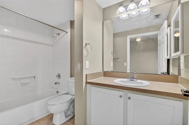 a white toilet and tub sitting next to a bathroom sink
