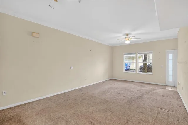 an empty room with a window and a ceiling fan