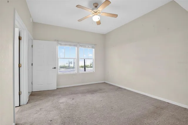 an empty room with closet and a ceiling fan