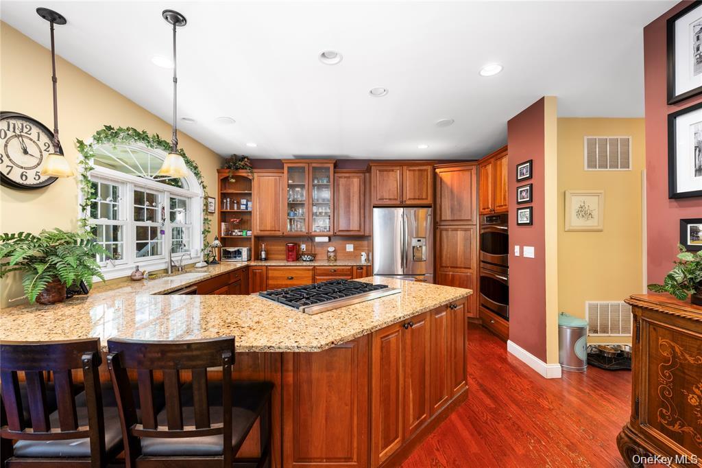 6 Old Town Road Beacon, NY 12508 - Photo 13 of 49 a kitchen with stainless steel appliances granite countertop a kitchen island a stove a refrigerator a dining table and chairs with wooden floor