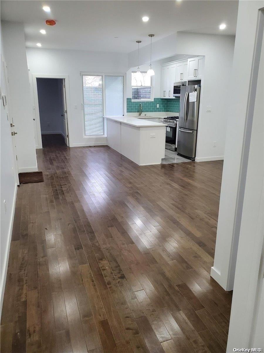 3043 Fulton Street Brooklyn, NY 11208 - Photo 12 of 14 a large room with wooden floor