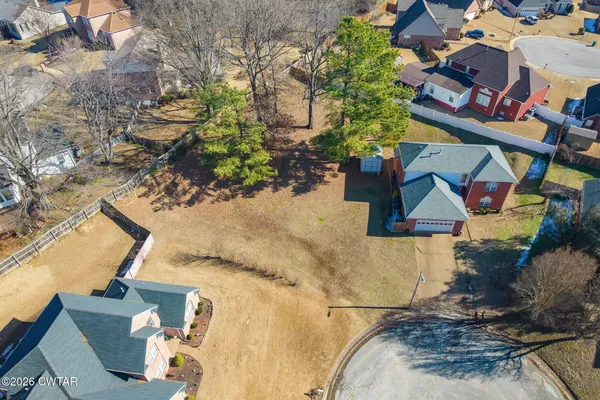 an aerial view of a house with a yard and wooden fence