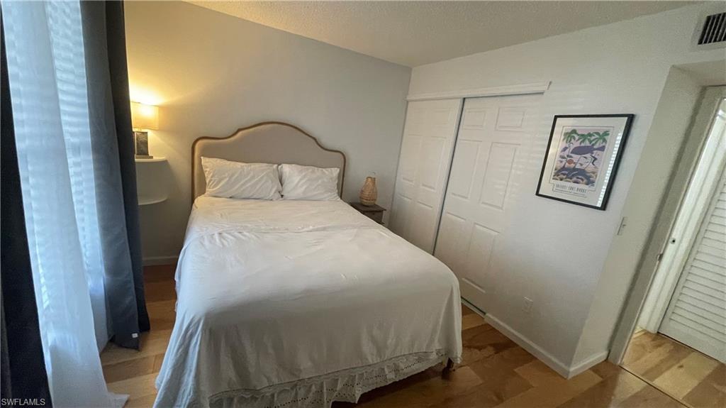 267 Quail Forest Boulevard, Unit 111 Naples, FL 34105 - Photo 26 of 41 a bedroom with a bed and wall painting