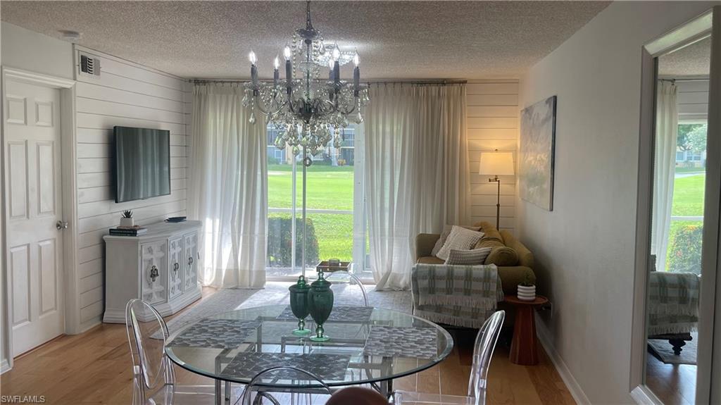 267 Quail Forest Boulevard, Unit 111 Naples, FL 34105 - Photo 6 of 41 a dining room with furniture a chandelier and window
