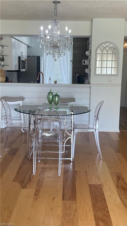 267 Quail Forest Boulevard, Unit 111 Naples, FL 34105 - Photo 7 of 41 a view of a dining room with furniture and chandelier