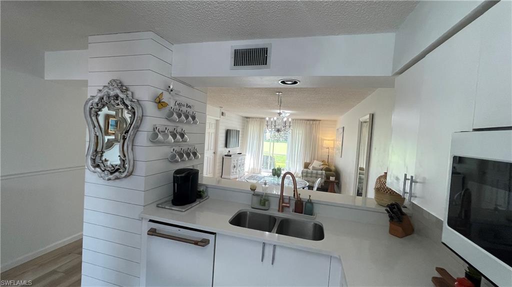 267 Quail Forest Boulevard, Unit 111 Naples, FL 34105 - Photo 8 of 41 a kitchen with sink and refrigerator