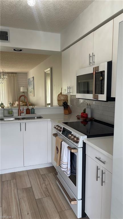 267 Quail Forest Boulevard, Unit 111 Naples, FL 34105 - Photo 10 of 41 a kitchen with stainless steel appliances a stove microwave and sink
