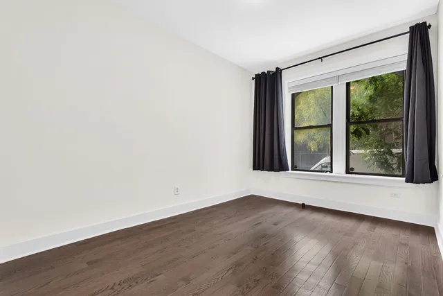 a living room with stainless steel appliances furniture a window and wooden floor